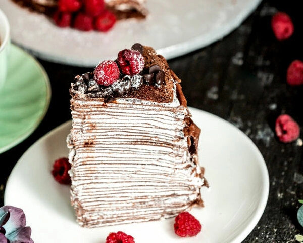 ova impresivna tiramisu torta od palacinki sadrzi 25 palacinki tankih poput papira 24 sloja prozracnog i aromaticnog nadjeva s okusom tiramisua posip od kakaa u prahu i tuceno slatko vrhnje na vrhu torte